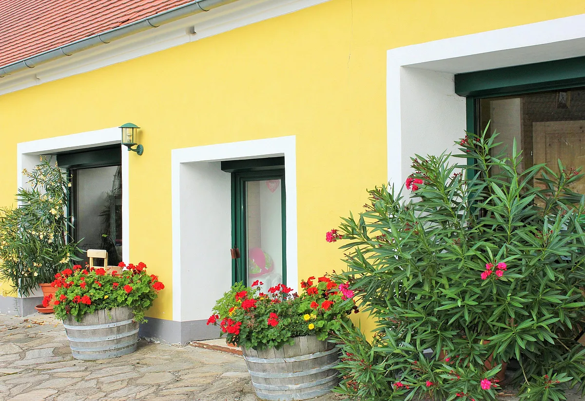 Blühender Innenhof des alten Forsthauses mit Geranien und Oleander
